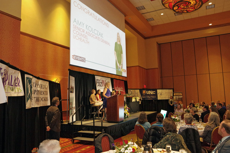 A speaker at the podium with the screen above