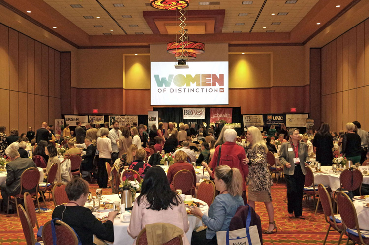 The Women of Distinction logo on the screen above the ballroom