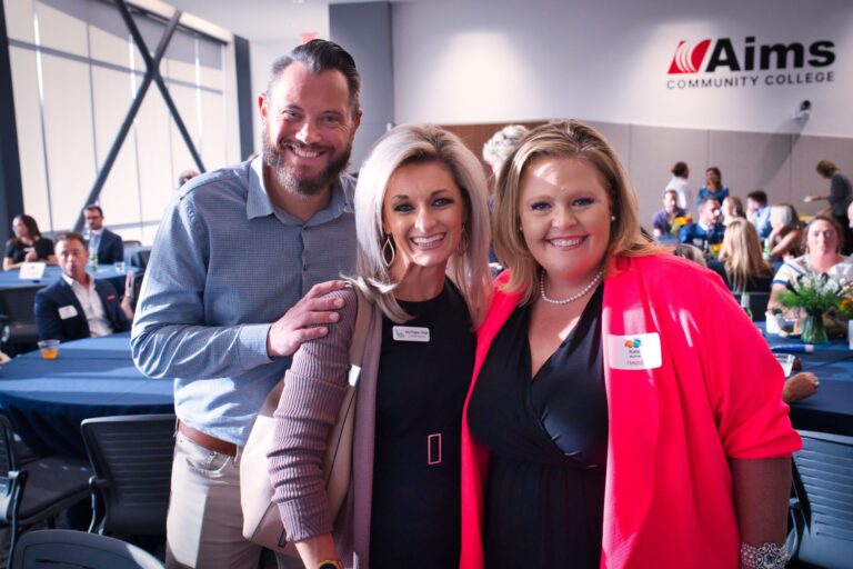Three guests posing together at a table