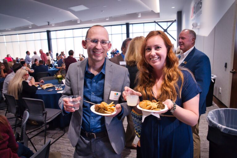 Two guests holding plates of food