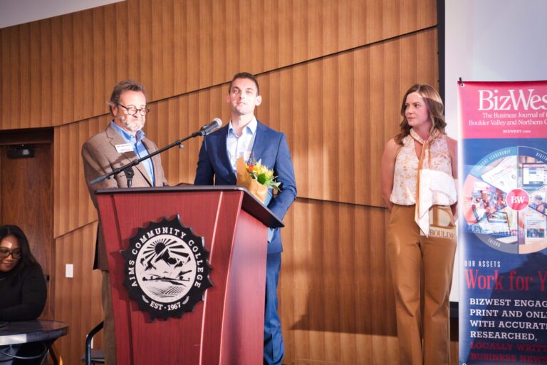 Three people at the podium on stage