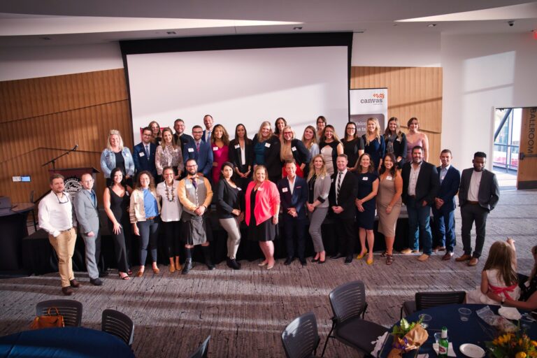A large group posing together at the front of the room