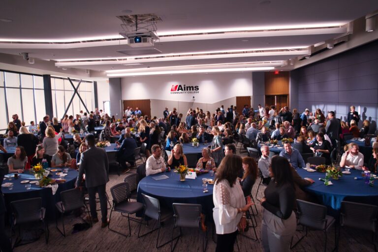 A full hall of guests seated at round tables