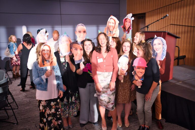 A group laughing with cut-out face photos