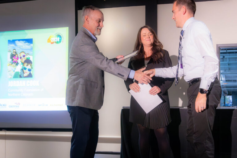 A presenter handing a certificate to an honoree on stage