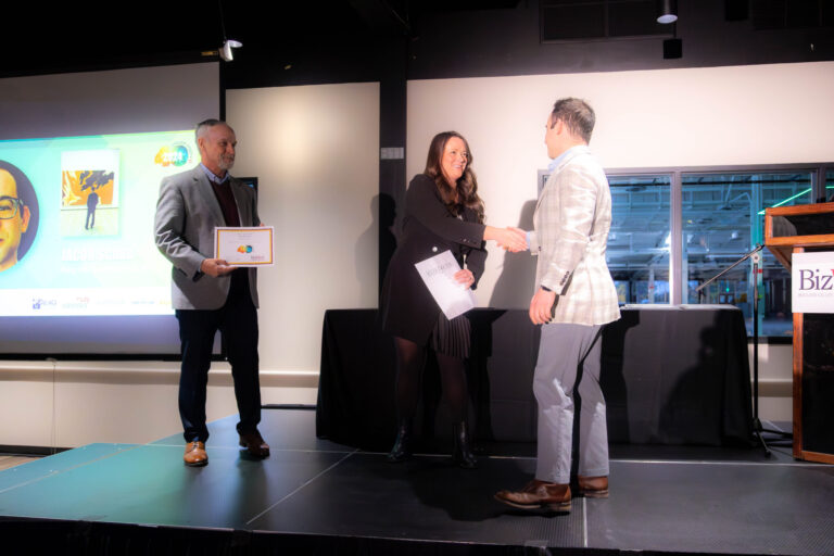 A handshake on stage as a certificate is presented