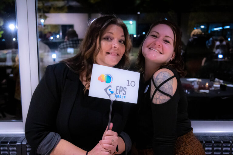 Two guests holding a table-number sign