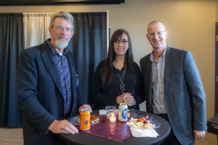 Three guests at a cocktail table during the 2025 reception