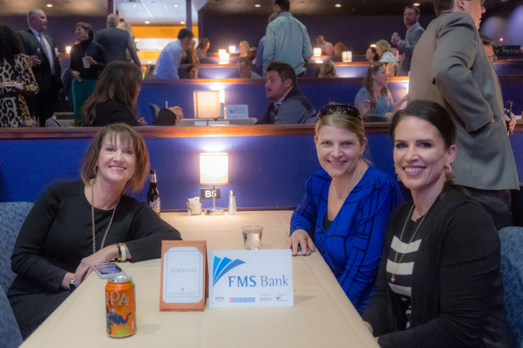 Guests at a table with an FMS Bank sponsor sign at the 2025 Most-Influential Business Leaders event (March 10, 2025, Candlelight Dinner Theater)