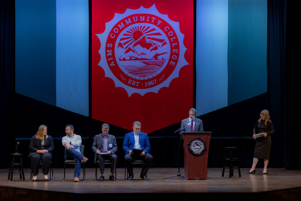 Four panelists seated on stage with a speaker at the podium at the 2025 Confluence and Net Zero Cities