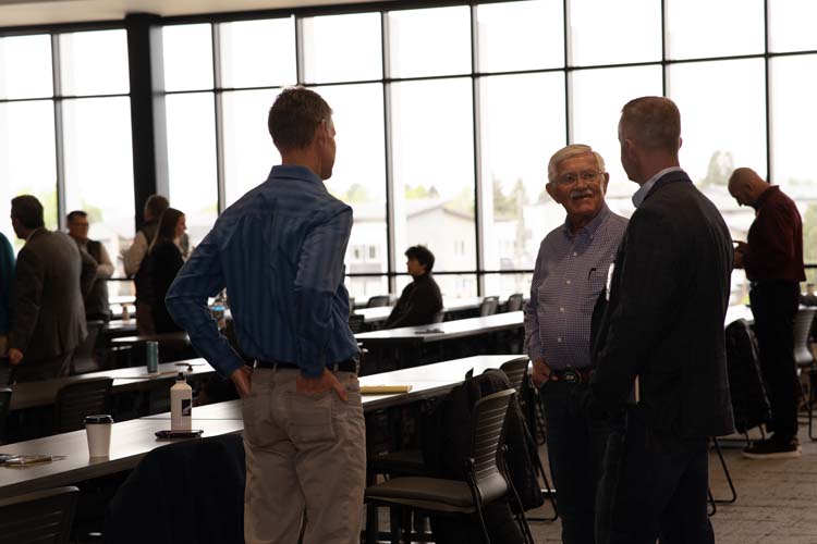 Attendees standing and talking in the conference room at Confluence 2026