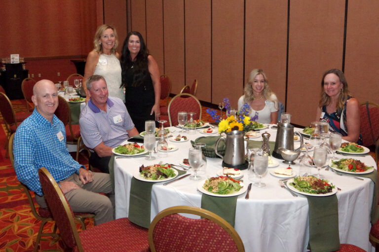 Guests seated at round tables set for dinner