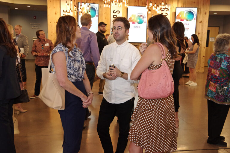 Guests talking in the lobby beneath 40 Under Forty screens