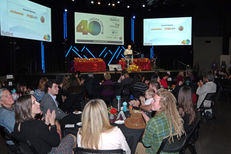 The audience at tables applauding during the program