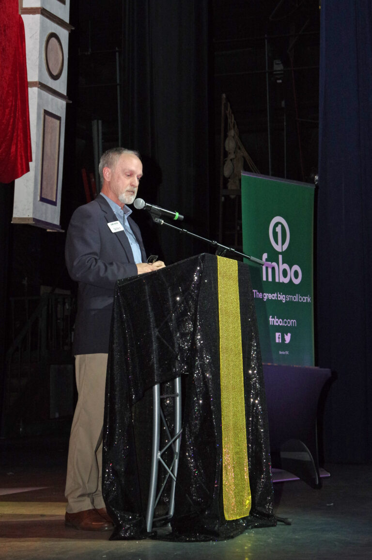 A speaker at the podium on stage at the 2024 Book of Lists Launch Party