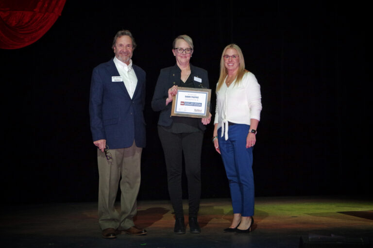 An honoree on stage holding an award at the 2024 Book of Lists Launch Party