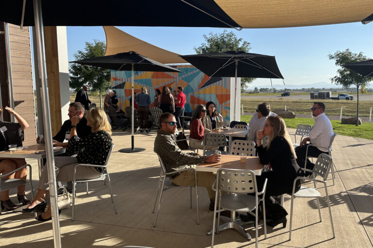 Guests seated under umbrellas on the patio