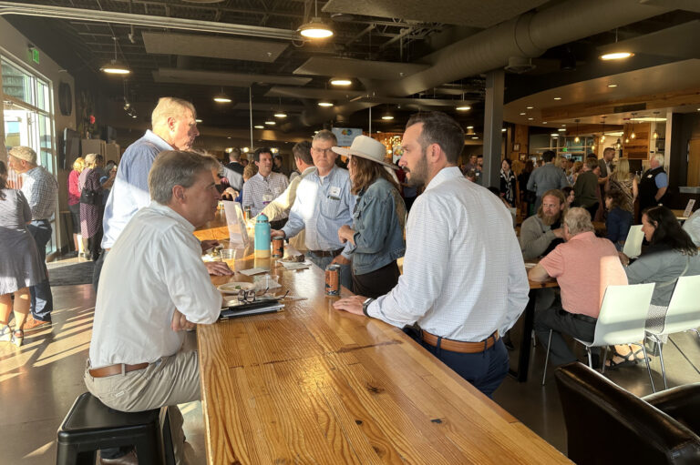 Guests talking at a long wooden table indoors
